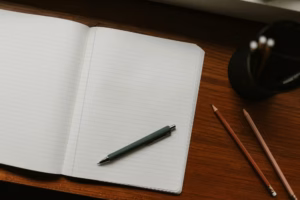 notepad open on table with pen next to it